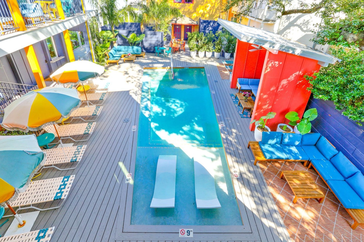 A Lower Garden District courtyard pool with umbrellas and loungers, seen from above